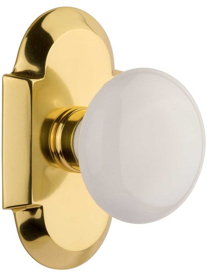 Arched Rosette Door Set with White Porcelain Knobs in Polished Brass.